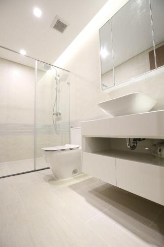 a white bathroom with a toilet and a sink at Investland- Vinhomes Metropolis one, two, three, four bedrooms in Hanoi