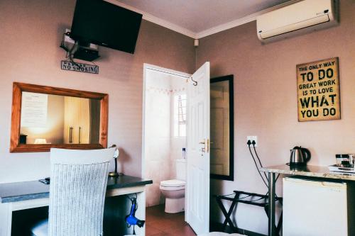 een badkamer met een toilet en een spiegel bij Villa Mosaiko in Kathu