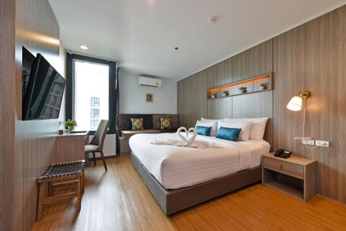 a hotel room with a large bed and a desk at Bedever Boutique Bangkok Hotel - BTS Phra Khanong in Bangkok