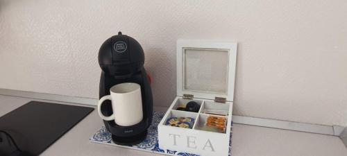 einen Tisch mit einer Kaffeetasse und einer Teebox in der Unterkunft Apartamentos Los Volcanes in Fuencaliente de la Palma