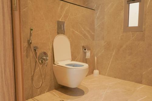 a bathroom with a white toilet and a shower at Hadeer Chalet in Riyadh