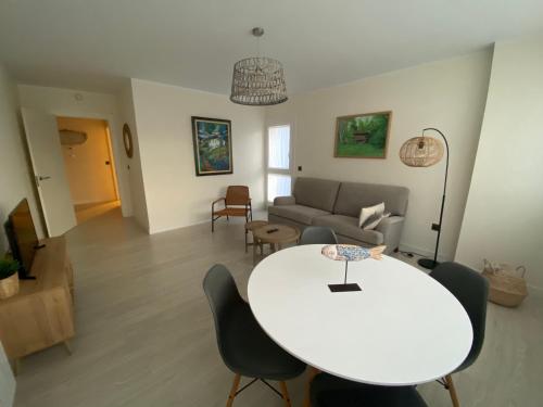 a living room with a white table and a couch at Piso acogedor entre mar y montaña in Posada de Llanes