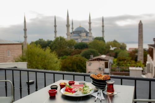 una mesa con un plato de comida en un balcón con una mezquita en HaciBayramApart en Estambul