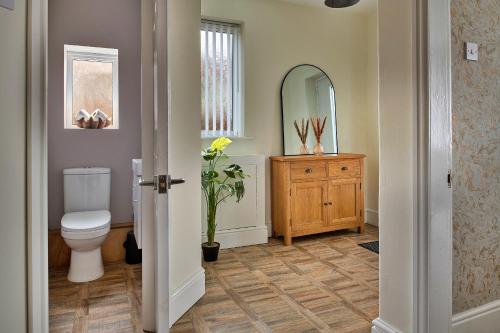 a bathroom with a toilet and a mirror at Finest Retreats - Shorelands in Prestatyn
