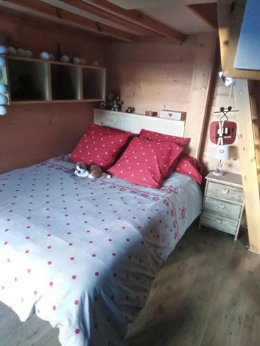 a bedroom with a large bed with red pillows at Séjour en famille dans un chalet cosy! in Briançon