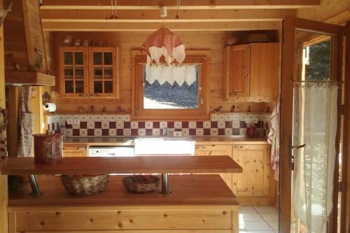 een keuken met houten kasten en een houten aanrecht bij Séjour en famille dans un chalet cosy! in Briançon