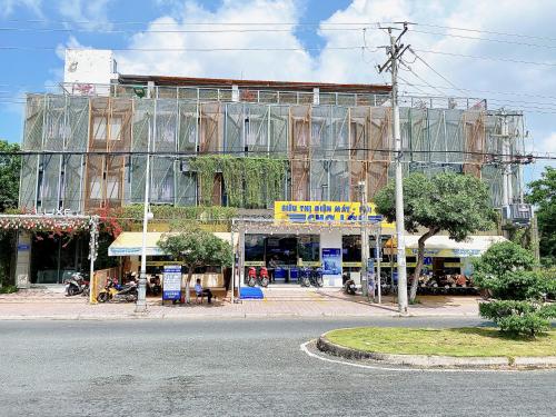 a large building with glass windows on a street at The Luxe Hotel Châu Đốc in Chau Doc