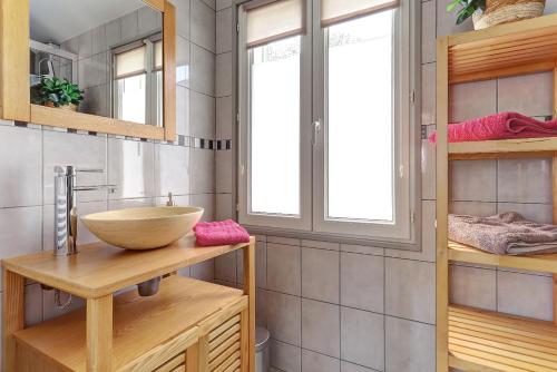 ein Badezimmer mit einem Spülbecken auf einer Holztheke in der Unterkunft La Petite Maison Du Montjard 