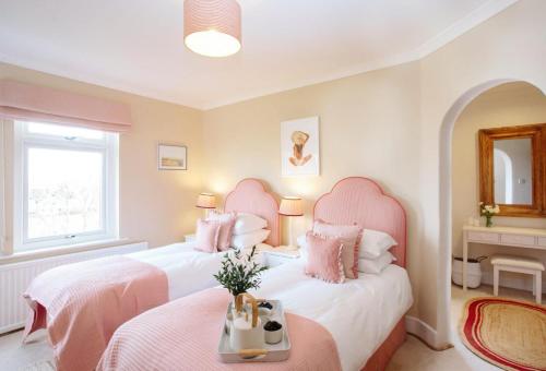 two beds in a room with pink pillows at Beautiful 5-Bed House in Port Isaac in Port Isaac