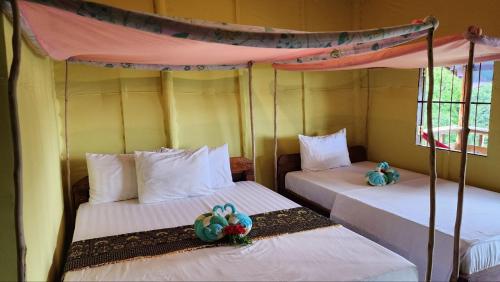 two beds in a room with two bedsitures at Kohrong Sea Views Bungalows in Koh Rong Island