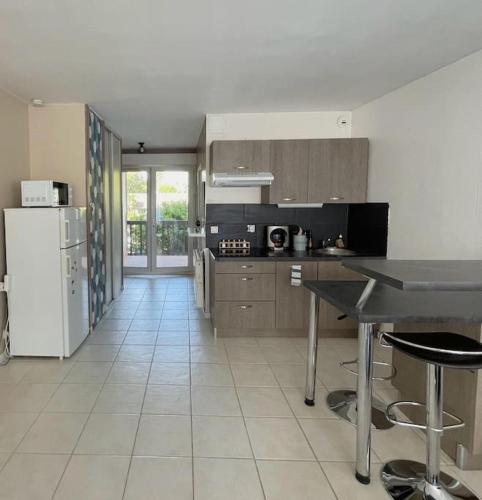 une cuisine avec une table et un réfrigérateur dans l'établissement Studio Cozy avec Terrasse en centre ville !, à Roissy-en-Brie