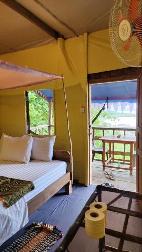 a bedroom with a bed in a tent with a porch at Kohrong Sea Views Bungalows in Koh Rong Island