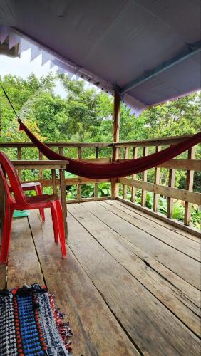 a hammock and a chair on a wooden deck at Kohrong Sea Views Bungalows in Koh Rong Island