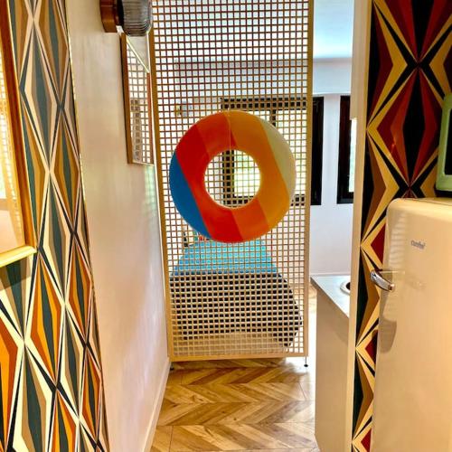 Cette chambre dispose d'une porte avec un objet coloré. dans l'établissement CAVALOC.FR STUDIO RETRORANGE, à Cavalaire-sur-Mer