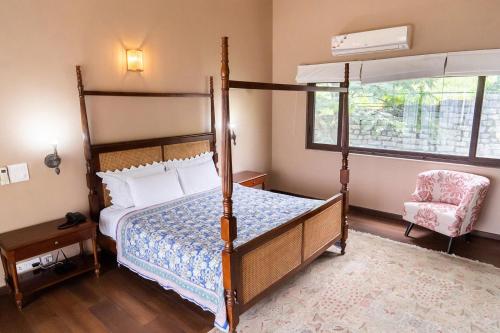 um quarto com uma cama de dossel e uma cadeira em villa 1314 em Kasauli