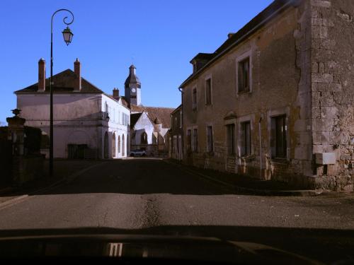 an empty street in an old building with a church at La Guirtelle in Lainsecq