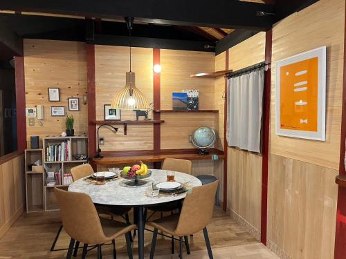 高松市一軒家貸切プライベートハウスotonarisan-駐車場無料 في تاكاماتسو: غرفة طعام مع طاولة وكراسي
