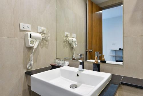 a bathroom with a white sink and a mirror at Bedever Boutique Bangkok Hotel - BTS Phra Khanong in Bangkok