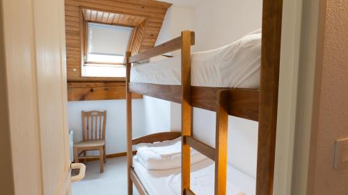 Cette petite chambre dispose de 2 lits superposés et d'une fenêtre. dans l'établissement Résidence Les Arches, à Saint-Lary-Soulan