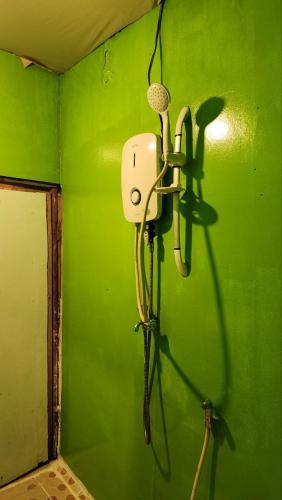 a room with a green wall with a microphone at Kohrong Sea Views Bungalows in Koh Rong Island