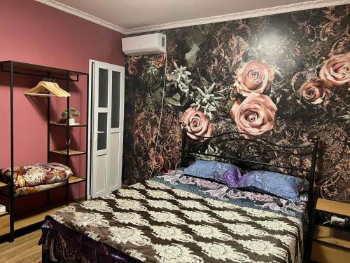 1 dormitorio con 1 cama con rosas en la pared en Комната с собственной ванной комнатой, en Chişinău
