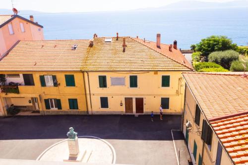 an aerial view of a large yellow building with the ocean at Hotel Il Telamonio in Talamone