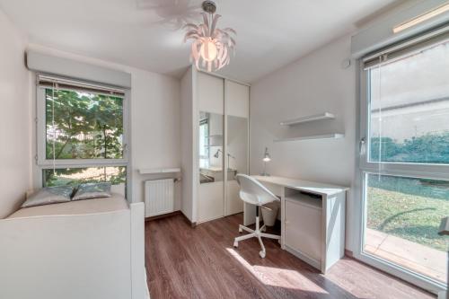 1 dormitorio con escritorio, 1 cama y ventana en Superbe appartement à Decines en Décines-Charpieu