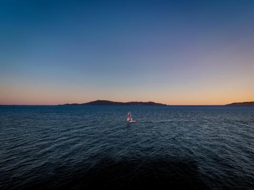 a small boat in the middle of a large body of water at Hotel Il Telamonio in Talamone