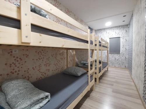 Łóżko piętrowe w pokoju z drewnianymi łóżkami piętrowymi w obiekcie Bar-celona w Wilnie