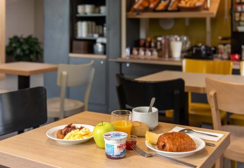 a table with two plates of breakfast food on it at B&B HOTEL Montpellier 1 in Saint-Jean-de-Védas