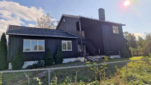 uma casa negra com uma vedação à frente. em Home Express em Asker