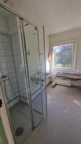 uma casa de banho com uma cabina de duche em vidro e um lavatório. em Home Express em Asker