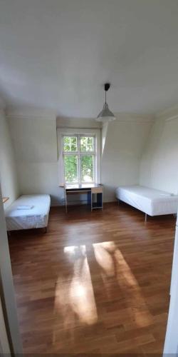 um quarto vazio com duas camas e uma janela em Home Express em Asker