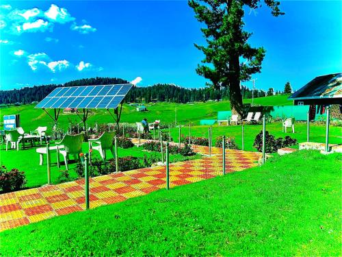 a solarium with a table and chairs in a field at Pine View Resort in Gulmarg