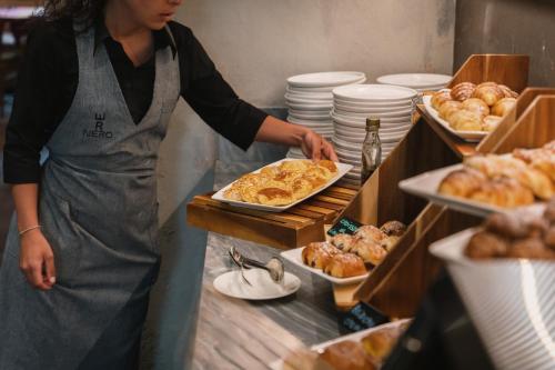 マリーナ・ディ・ピエトラサンタにあるRe Versiliana Hotelのキッチンに立って料理の準備をしている女性