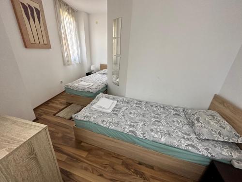 2 letti in una camera con pavimenti in legno di Ramada 2 - Apartment a Bansko