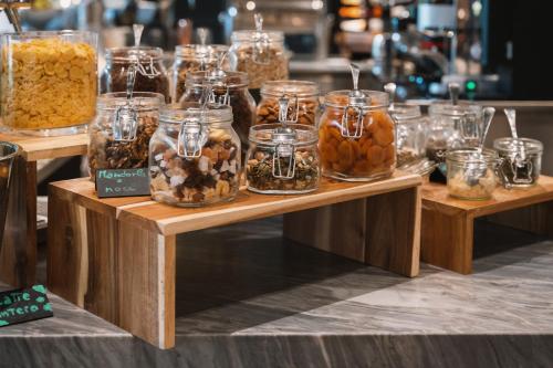 マリーナ・ディ・ピエトラサンタにあるRe Versiliana Hotelのテーブルの上にナッツの瓶が並べられている