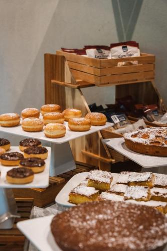 マリーナ・ディ・ピエトラサンタにあるRe Versiliana Hotelの様々な種類のケーキやペストリーを展示