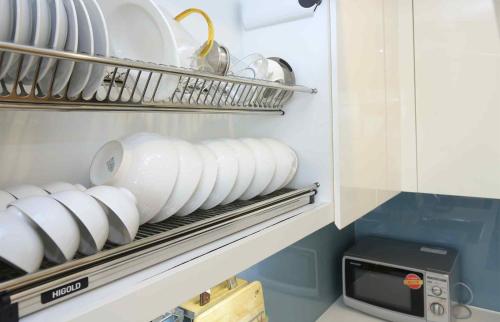 a stack of plates and bowls on a shelf in a refrigerator at Investland- Vinhomes Metropolis one, two, three, four bedrooms in Hanoi