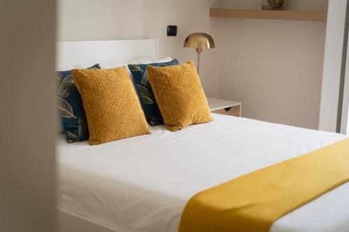 a bedroom with a bed with yellow and blue pillows at santa tecla living faravelli 4 in Milan