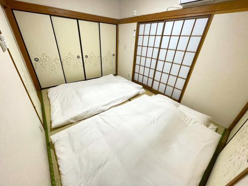 two beds in a small room with two windows at Tatami house Skytree view Asakusa line in Tokyo