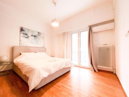 - une chambre avec un lit et une grande fenêtre dans l'établissement Harmonia ANhome Premium Selections, à Athènes