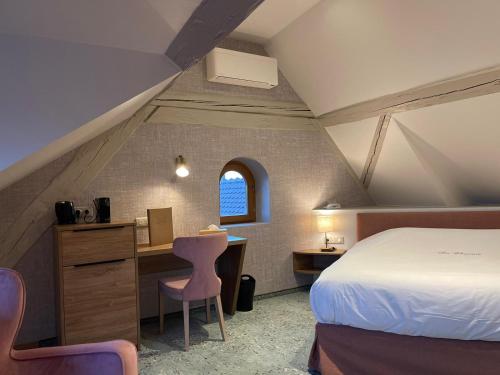 a bedroom with a bed and a desk and a window at Hôtel Restaurant La Charrue in Sand