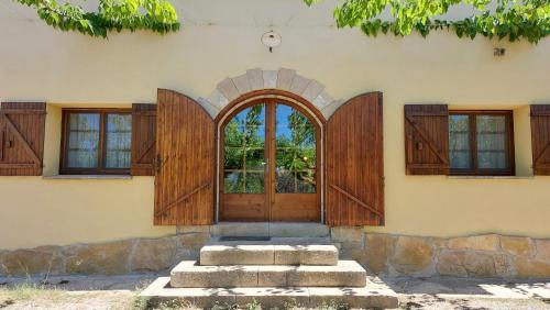 an entrance to a house with wooden doors at La Calma Montblanc Prenafeta in Prenafeta