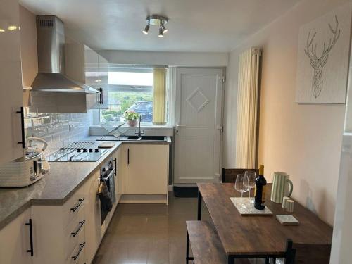 - une cuisine avec un comptoir et une table dans l'établissement Immaculate 1-Bed House in Newtown Disley, à Stockport