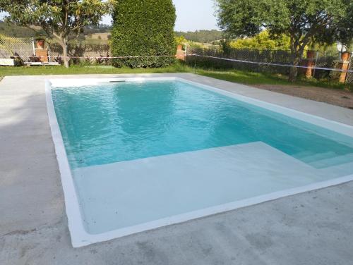a swimming pool with blue water in a backyard at Casa familiar con piscina in Barcelona