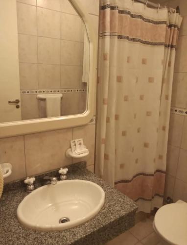 a bathroom with a sink and a mirror and a shower at Hotel Nontue Abasto Buenos Aires in Buenos Aires