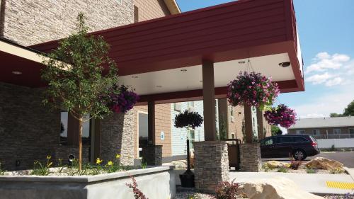 a building with flower baskets in front of it at Ledgestone Suites Hotel Vernal in Vernal