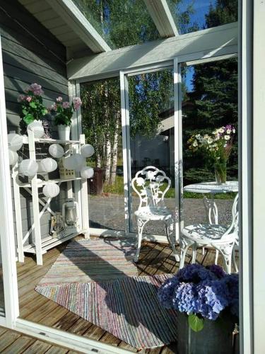 a screened in porch with chairs and a table at Mini house Imatra with own garden in Imatra