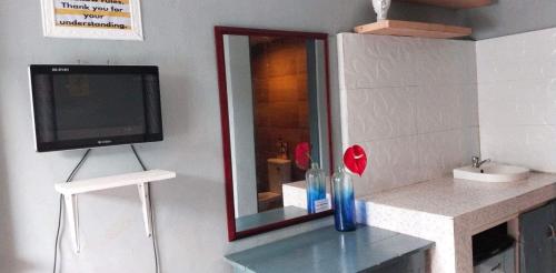 a bathroom with a tv and a counter with a mirror at 25th RESIDENCES- LACSON BACOLOD in Bacolod